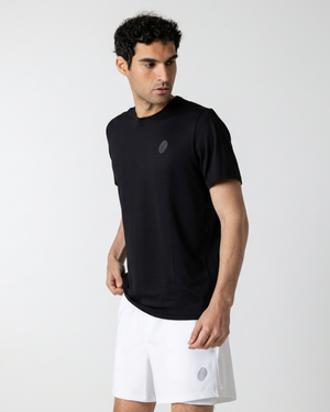 Man wearing a black t-shirt and white shorts on a light gray background