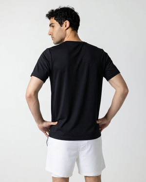 Man wearing a black t-shirt and white shorts on a light gray background