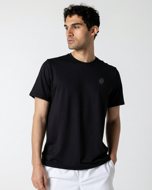 Man wearing a black t-shirt with a small logo on a white background
