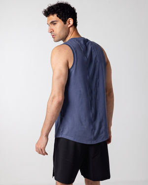 Man wearing a navy tank top and black shorts on a white background